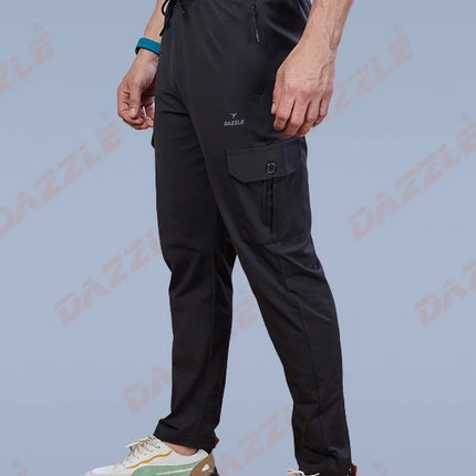 Person wearing black pants and white sneakers on a light blue background