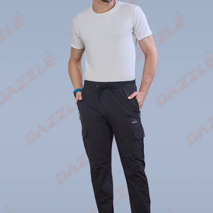 Man wearing black cargo pants and a white t-shirt on a light blue background with 'Gazzle' branding.
