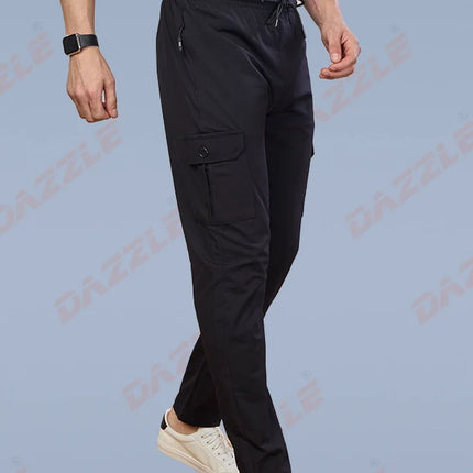Person wearing black cargo pants and white sneakers on a light blue background with 'Gazelle' branding.