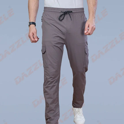 Person wearing gray cargo pants and white sneakers on a light blue background with 'Gazelle' branding.